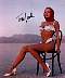 Traci Lords, stock color photo. Wearing bikini, sitting on chair in desert flats