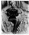 Zsa Zsa Gabor, stock black & white photo of her sitting, holding a fan